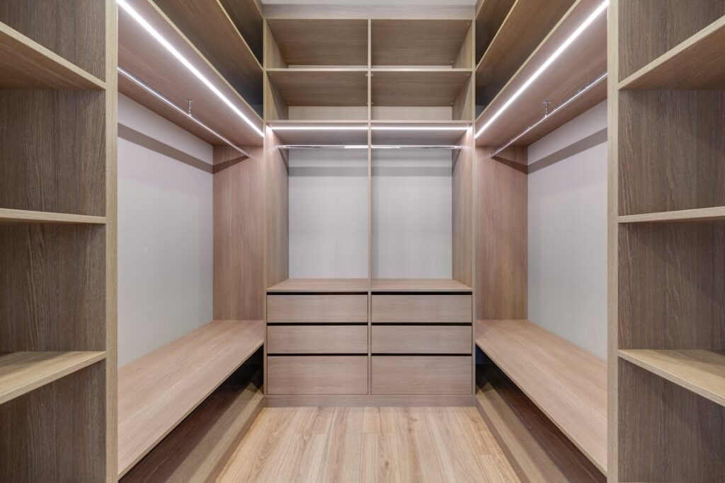 A bright closet with wooden shelves.
