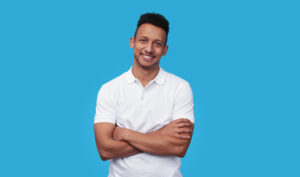 Confident ethnic man smiling for camera wearing a white men's polo shirt