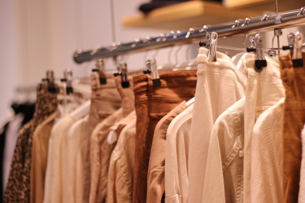  Neutral-toned clothes hanging on a rack in a well-organized wardrobe.