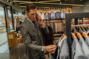 a man adjusting his work wardrobe, choosing a suit