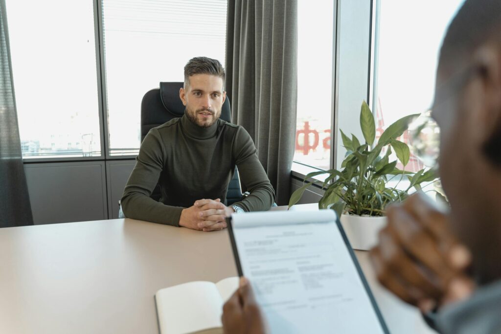 A man sitting opposite his employer during a job interview