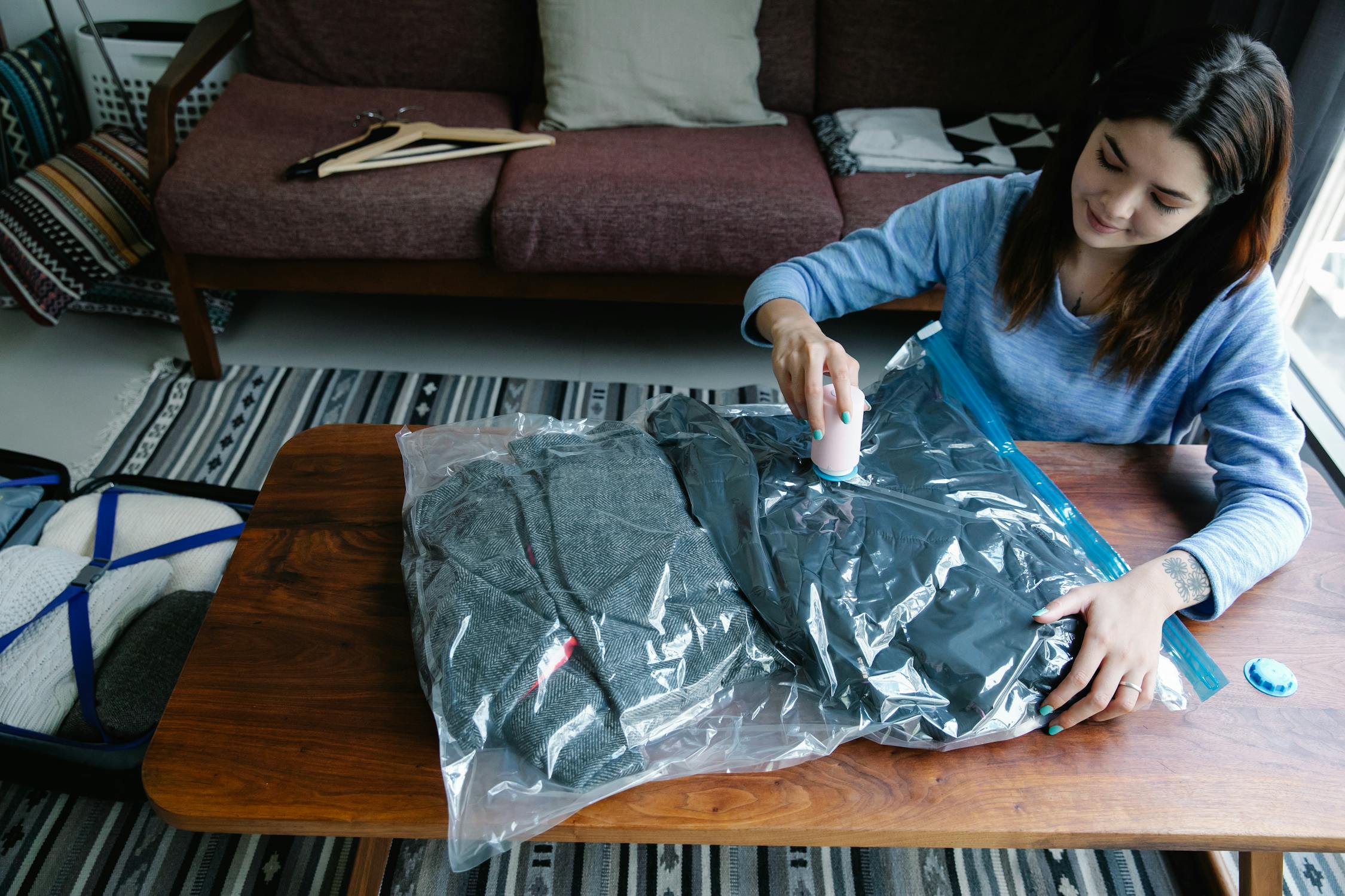 A woman vacuum-sealing bulky clothes.