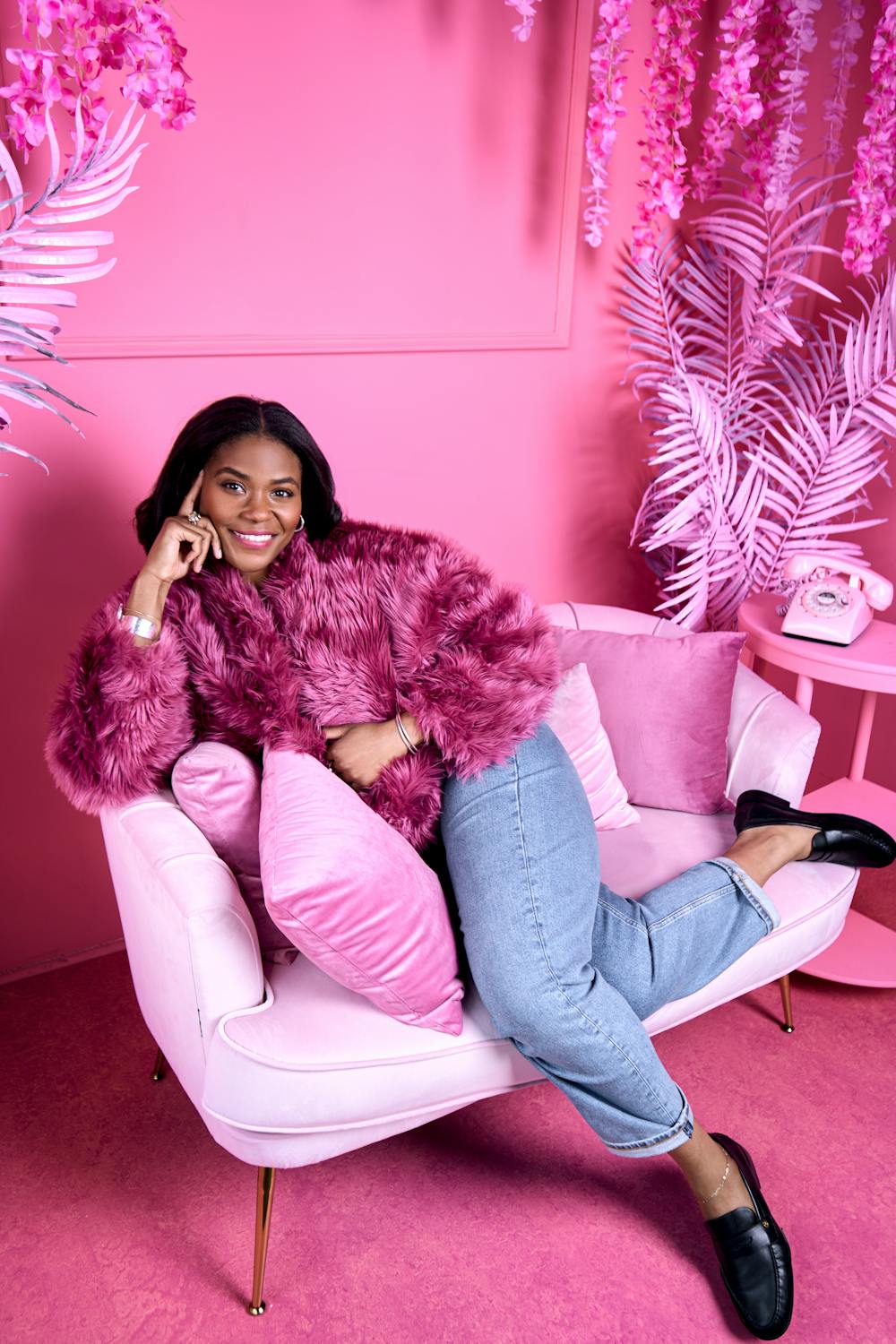 barbie aesthetic in home decor: pink walls, pink chair, pink throw pillows, pink accessories